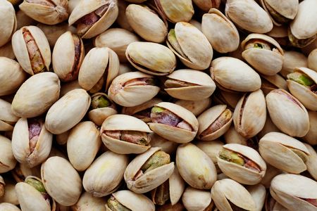 Roasted and salted pistachios in their shells as an abstract background texture