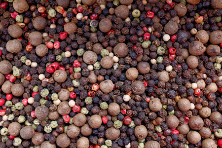 Mixed peppercorns - black, white, pink, green, pimento - as an abstract background texture