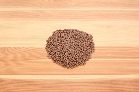 Brown lentils on a wooden background, pine wood grainの写真素材