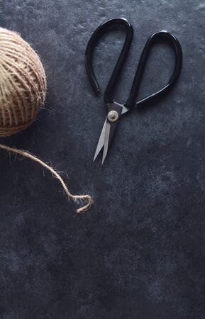 Retro florist scissors with detail of rough hessian twine on grey background with copy spaceの写真素材