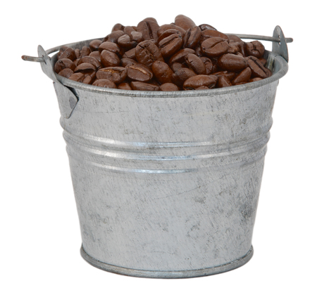 Dark roasted coffee beans in a miniature metal bucket, isolated on a white backgroundの写真素材