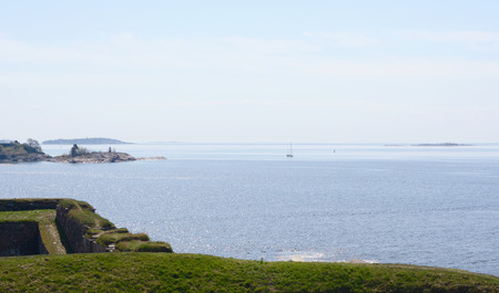 View from grassy hillside across Finnish waters from sea fortress Suomenlinna, Finlandのeditorial素材