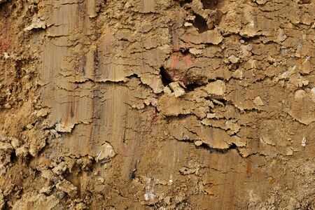 Scraped smooth golden brown Weald clay - abstract earth background texture - with streaks of colour