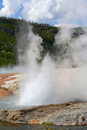 Landscape with geyser erupting in Yellowstone National Park