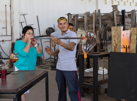 Cabo San Lucas, MEXICO - April 8 2014- An unidentified glass blower shows an unidentified woman how to blow glass at glass blown factory on  April 8 2014  in Cabo San Lucas, Mexico.のeditorial素材