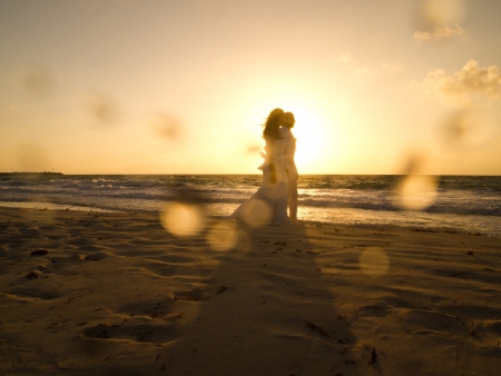 A bride and groom walk on the beaches of Puerto Morelos, Mexico shortly after sunrise  の写真素材