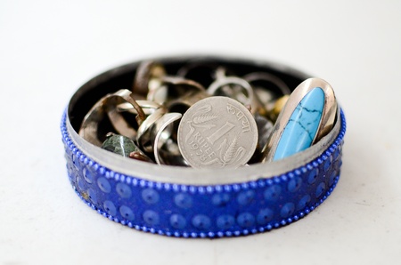 One Rupee coin in a jewelry box surrounded by an assortment of rings  の写真素材