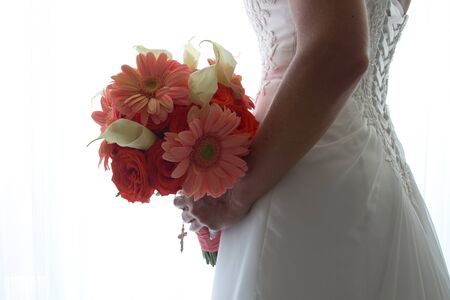 A bride holds her bouquet while getting ready for her wedding  の写真素材