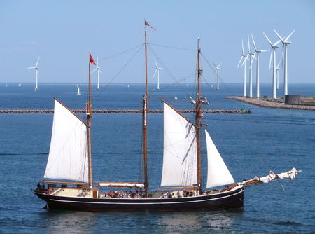 wind power past & future - tall ship with wind turbines in backgroundの写真素材
