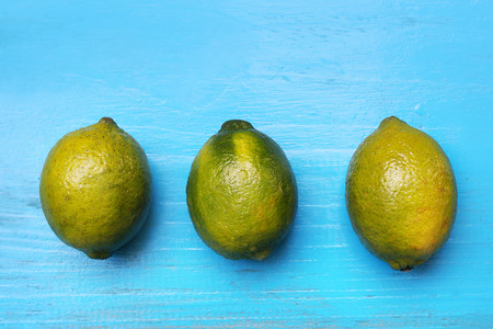 Fresh limes on wooden blue background