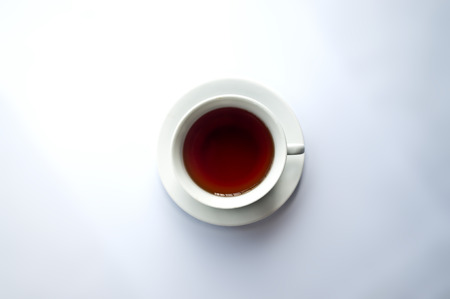 White tea cup with red tea on white backgroundの写真素材