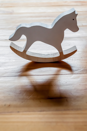 Wooden miniature rocking horse on wooden table top.の写真素材