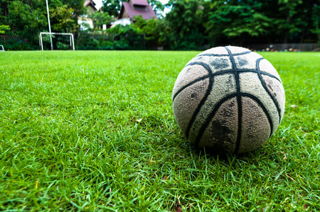 old used ball on green grass fieldの写真素材
