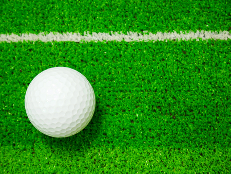 White golf ball on artificial turfの写真素材