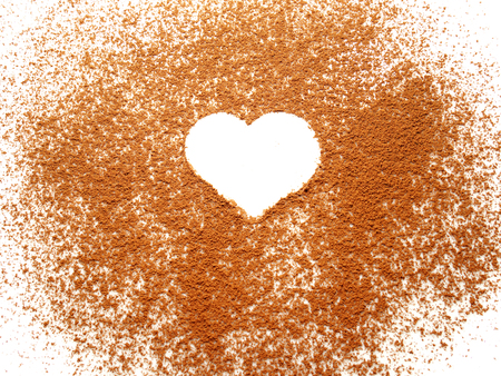 Heart shape on spreading cocoa powder on white backgroundの写真素材