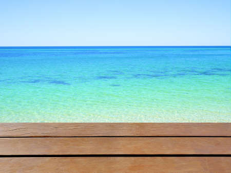 Clear blue sea and wooden tableの写真素材