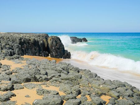 The surf crashing against rocks at the beach