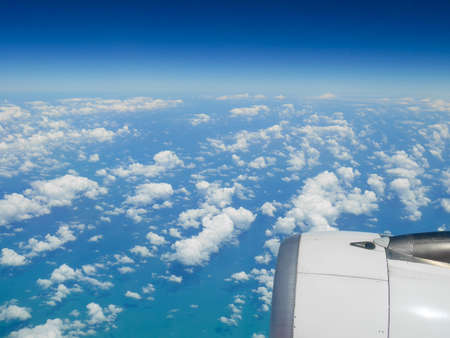 Aerial view of blue ocean and clouds from airplane window