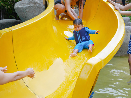 Baby boy sliding from water slideの写真素材