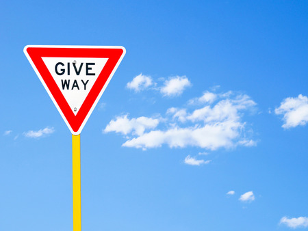 Give way sign on blue sky background (with clipping path)