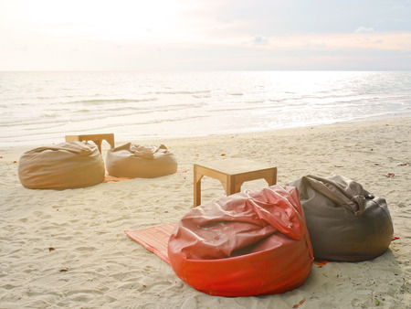 Bean bags and tables set on the beachの写真素材