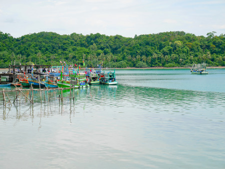 Koh Chang Island, Thailand - July 23: Colorful fishing boats at fish dock and people bring buckets of fish to vehicles on July 23, 2016のeditorial素材