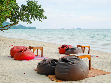 Bean bags and tables set on the beachの写真素材