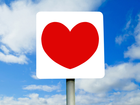 Red heart sign on blue skies and clouds. Valentine's day background.の写真素材