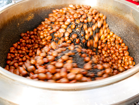 Chinese chestnuts being roasted in big potの写真素材