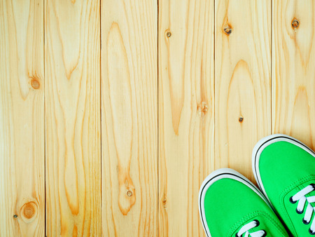 Green canvas shoes on wooden background. Top view. Copy space.の写真素材