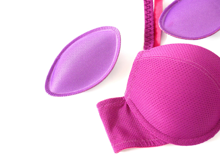 Bra pads and purple brassiere isolated on white backgroundの写真素材