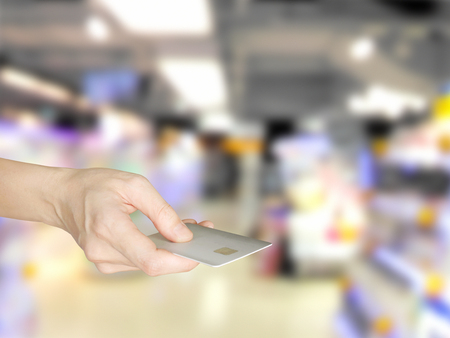 Hand giving credit card at supermarket checkoutの写真素材