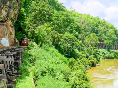 World war II historic railway, known as the Death Railway with tourists on the train over Kwai Noi Riverの写真素材