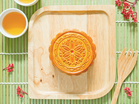 Mooncake on a wooden plate for Mid-Autumn Festival or Harvest Festivalの写真素材