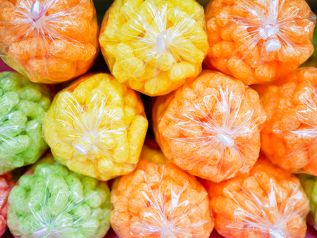 Stack of colorful crispy snacks in clear plastic bags. Abstract background.の写真素材
