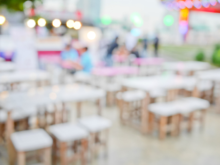 Blurred customers dining at outdoor restaurant with colorful bokeh light backgroundの写真素材