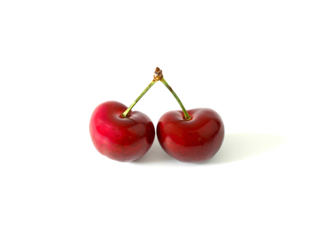 Heart shaped two cherries isolated on white background. Love concept.の写真素材