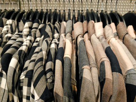 Tartan collared shirts or dress shirts hanging in clothing shop in shopping mall