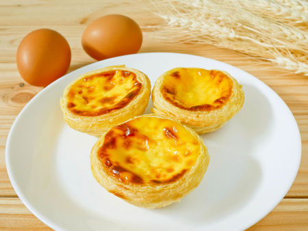 Fresh baked egg tarts or custard tarts (pastel de nata) on a white plate
