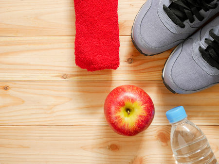 Exercise and fitness equipment with red apple on wooden background in the gym with copy space. Top view. Wellness conceptの写真素材