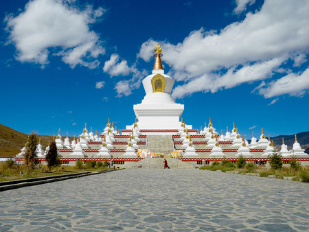 A monk walking around Namgyal Tallinn Pagoda in Daocheng, Sichuan, Chinaの写真素材