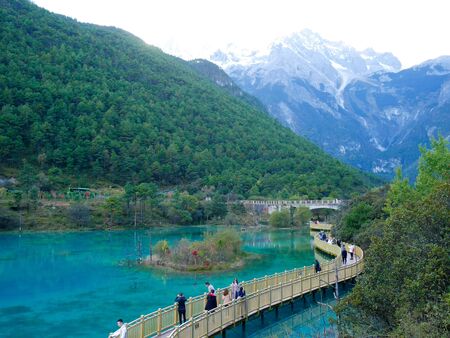 Lijiang, China - October 17, 2018: Tourists enjoy taking photos at Blue Moon Valley with Jade Dragon Snow Mountain in the backgroundのeditorial素材
