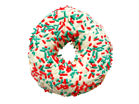 Delicious white glazed donut with colorful festive sugar strand sprinkles isolated on whiteの写真素材