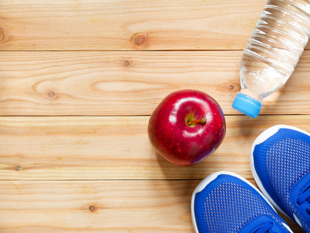Exercise and fitness equipment with red apple on wooden  in the gym with copy space. Top view. Wellness conceptの写真素材