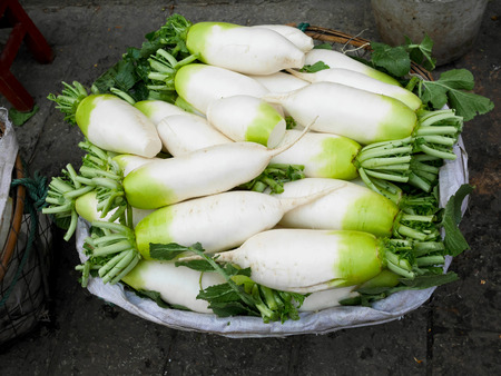 Asian long white radishes or Daikon in a basket in marketの写真素材