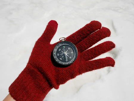 Traveler's hand holding compass with snowの写真素材
