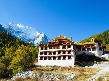 Chonggu monastery with snow capped mountains in Yading Nature Reserve, Sichuan, Chinaの写真素材
