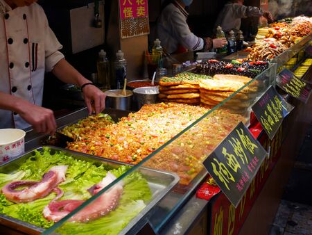 Lijiang, China - April 22, 2019: The cooks prepare and cook their food at food court in the old town of Lijiangのeditorial素材