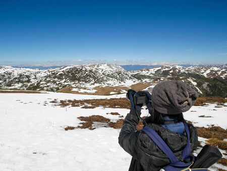 Traveler taking photos of snow mountain in China