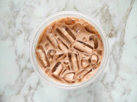 Iced chocolate in takeaway cup on the table. Top view.